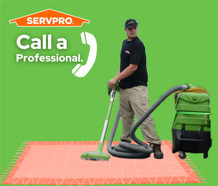 man extracting water from a rug on the ground with a SERVPRO water vacuum, text says "call a professional" with a phone by it